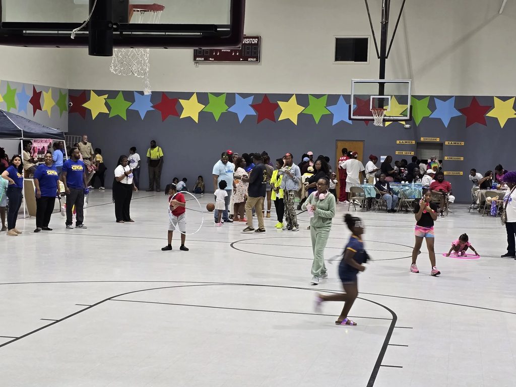 Families and children at a community event in a school gymnasium